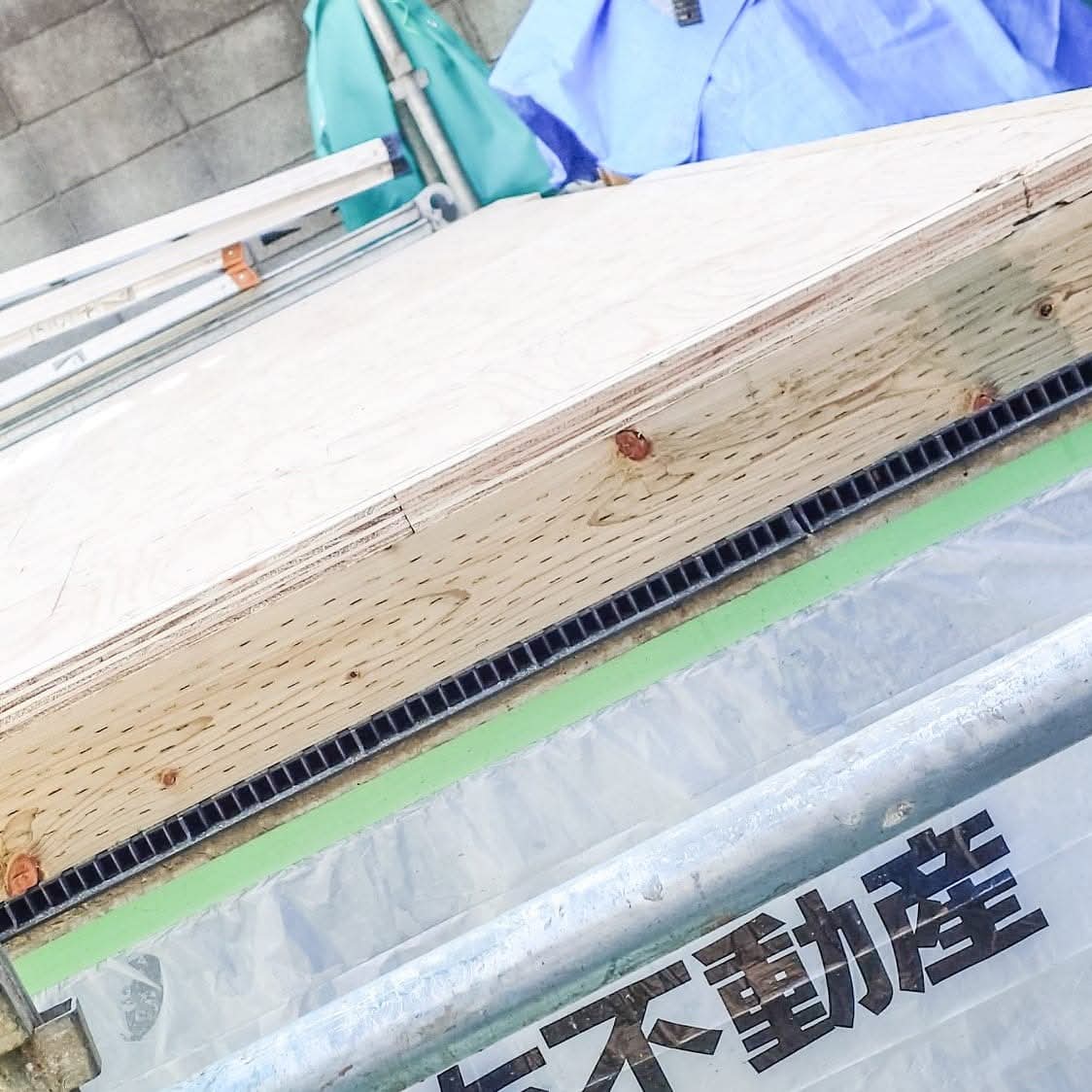 基礎の上に置かれた基礎パッキン（黒い櫛状の部材、厚さ20mm）。その上に防腐・防蟻処理された土台の木枠（厚さ80mm）、さらに構造用合板（厚さ28mm）が載せられる