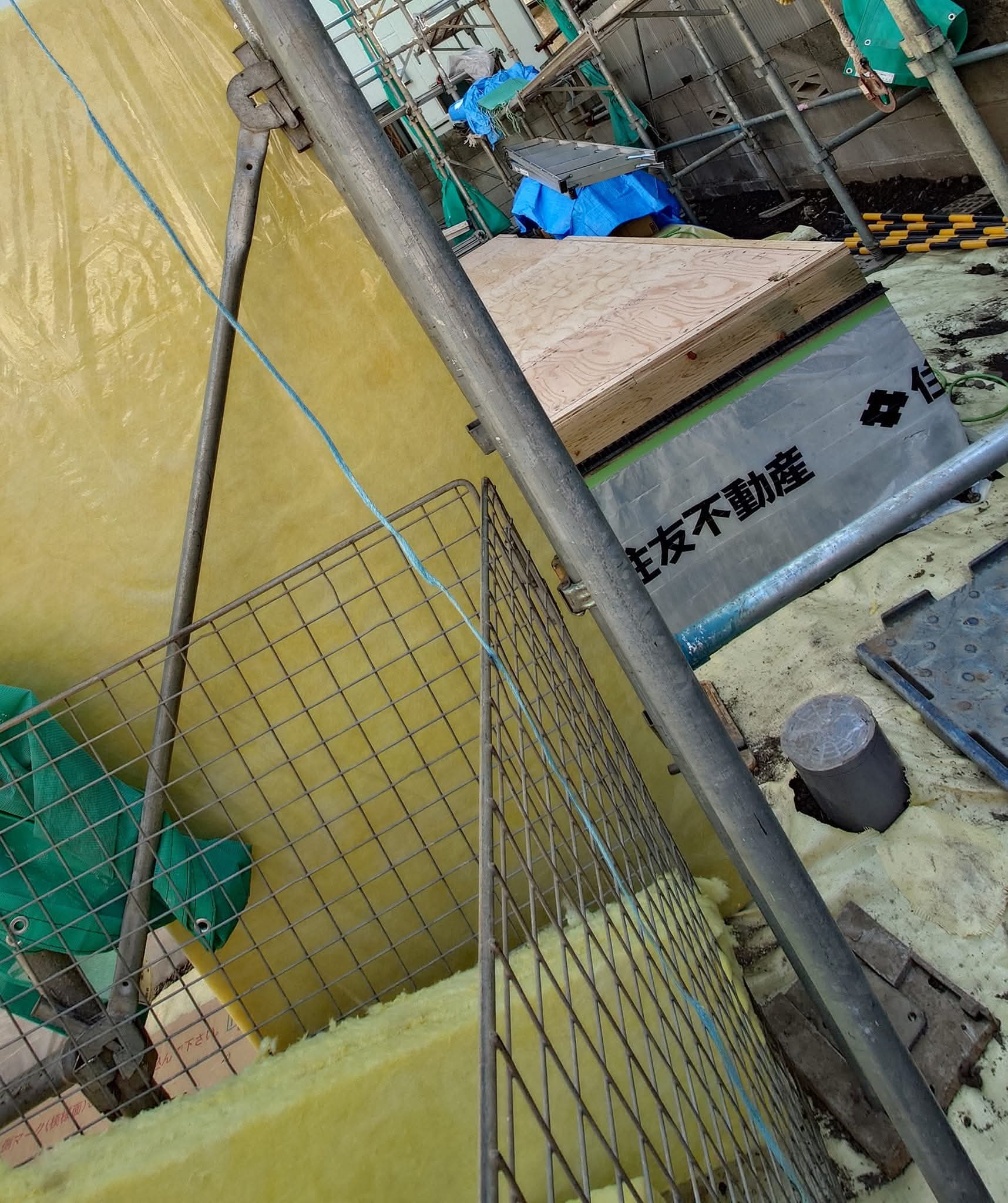 土台の内側に敷き詰められた高性能グラスウール（住宅用グラスウール32K、厚さ80mm）。家全体を断熱材を包む設計思想は、床下にも徹底されている