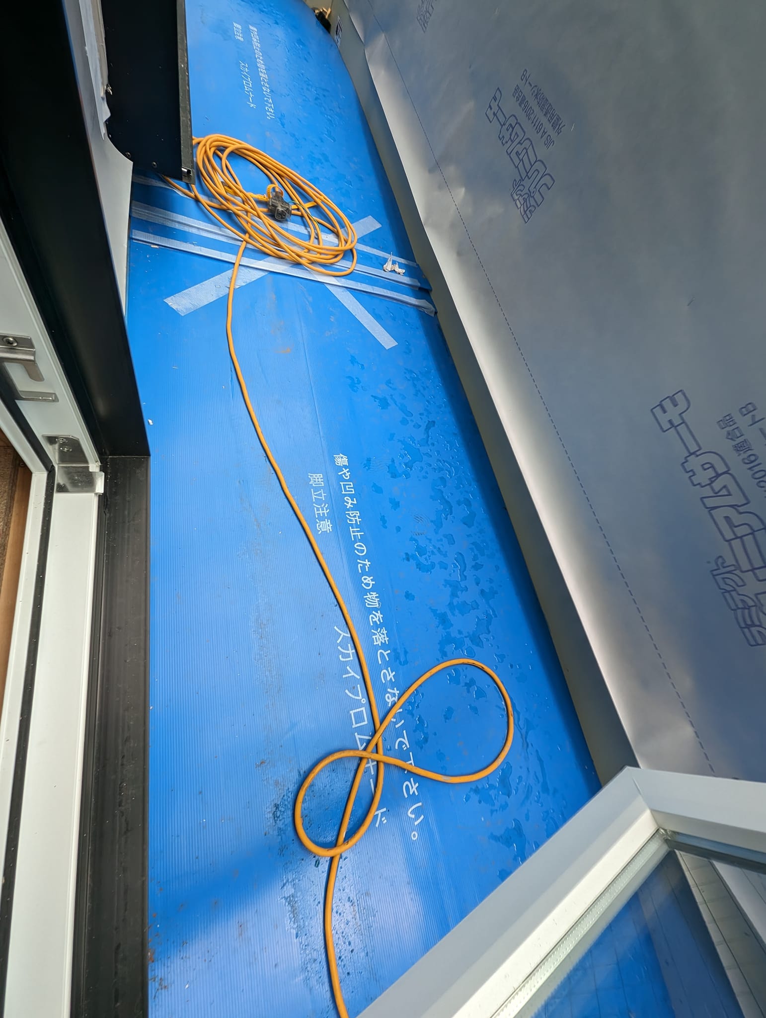 バルコニーに設置されたスカイプロムナード。青い養生シートでクリーニング工程まで保護されている