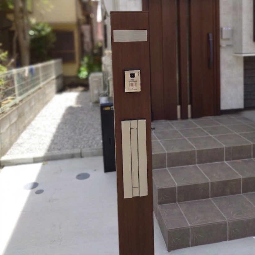 YKKap機能門柱B01型。本体はショコラウォールナットで、玄関ドアと統一した