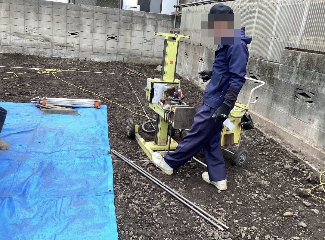 地盤調査(スクリューウエイト貫入試験)の機械を操作する作業員